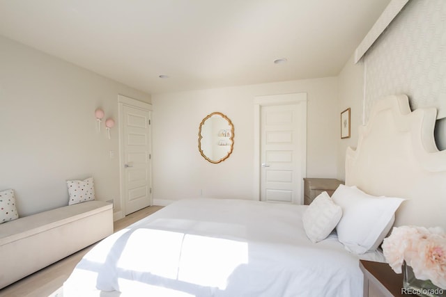 bedroom featuring light wood-style floors and baseboards