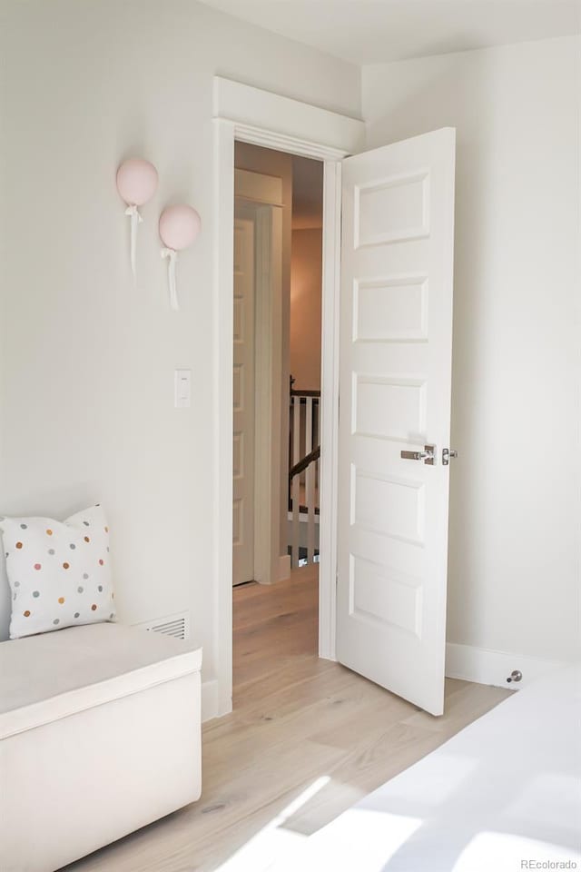 interior space featuring light wood-type flooring, baseboards, and visible vents