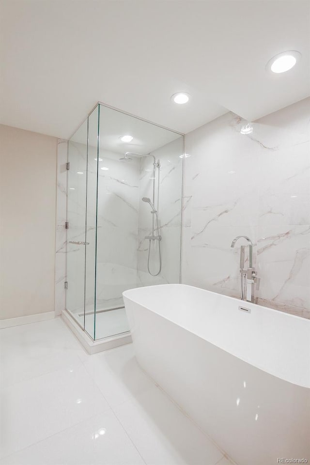 bathroom with recessed lighting, a marble finish shower, and a soaking tub