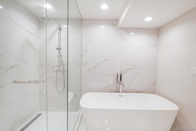 full bath featuring a soaking tub, recessed lighting, and a marble finish shower