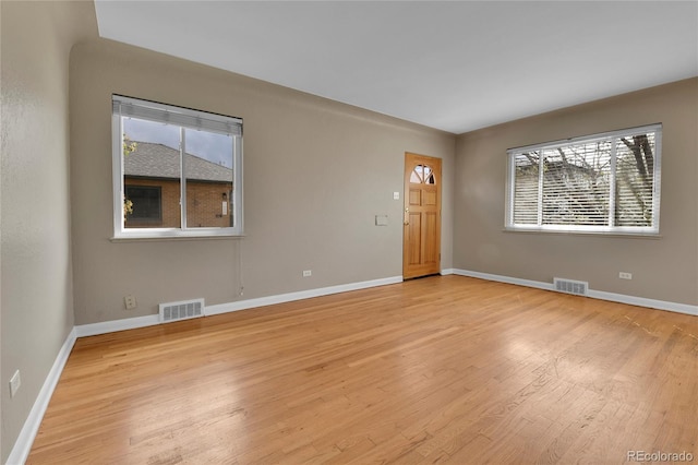 interior space featuring visible vents, light wood finished floors, and baseboards