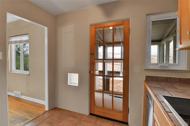 doorway to outside with visible vents and light tile patterned floors