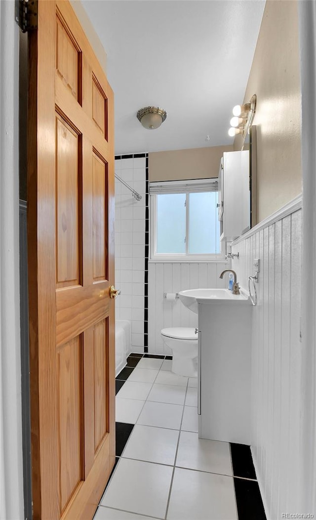 bathroom featuring tile walls, vanity, tile patterned floors, toilet, and tub / shower combination