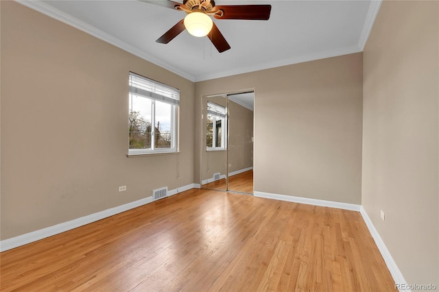 unfurnished room with a ceiling fan, visible vents, crown molding, baseboards, and light wood-style floors