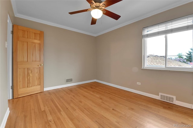 empty room featuring a ceiling fan, visible vents, crown molding, baseboards, and light wood-style floors