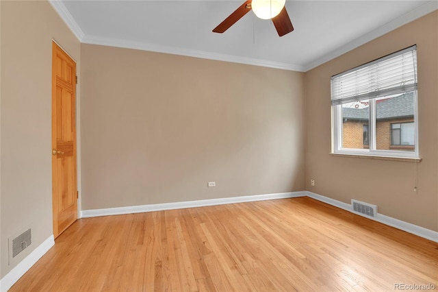 spare room featuring visible vents, ornamental molding, and light wood finished floors