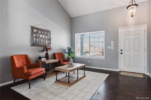 entrance foyer featuring hardwood / wood-style flooring, high vaulted ceiling, and an inviting chandelier