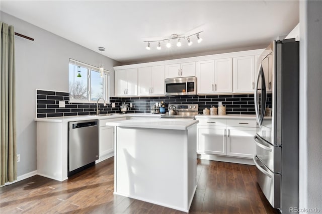 kitchen with hanging light fixtures, white cabinets, a center island, and stainless steel appliances