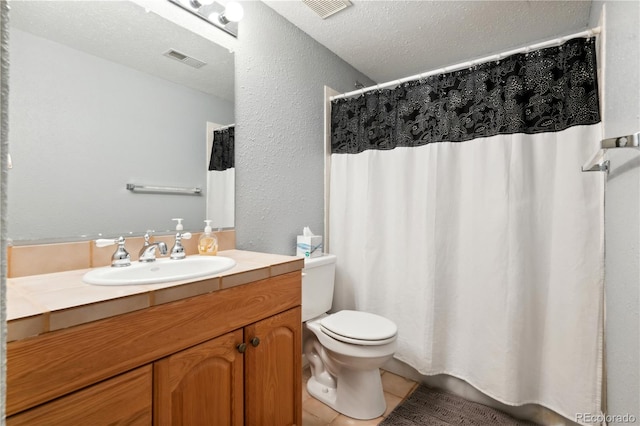 bathroom with tile patterned floors, a textured ceiling, toilet, and vanity