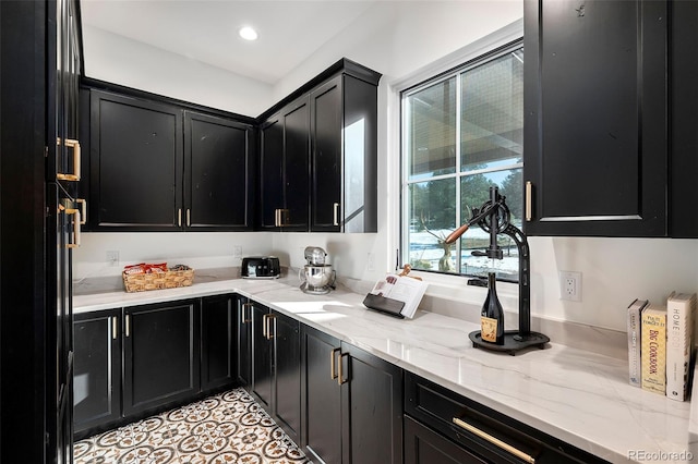 bar with light tile patterned floors and light stone counters