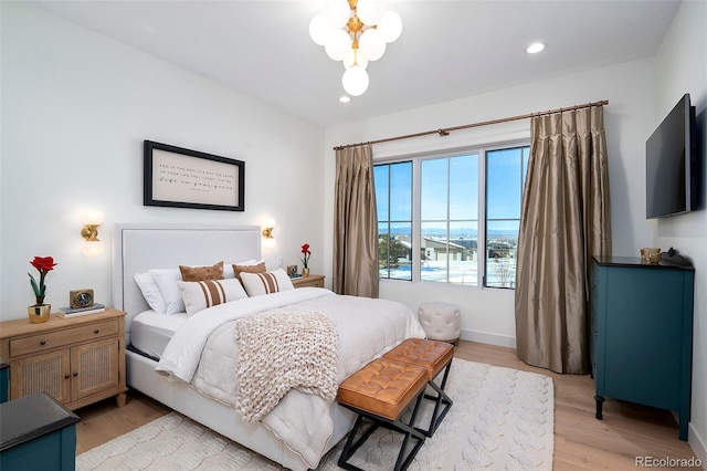 bedroom with a chandelier and light hardwood / wood-style flooring