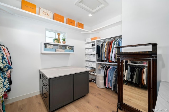 walk in closet with light hardwood / wood-style flooring