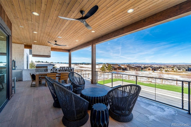 view of patio / terrace with area for grilling, ceiling fan, and an outdoor kitchen