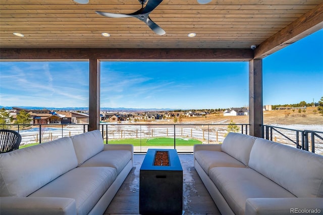 view of patio featuring ceiling fan and an outdoor living space with a fire pit