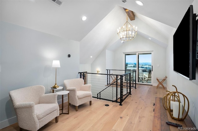 living area featuring lofted ceiling with beams, light hardwood / wood-style floors, and a notable chandelier