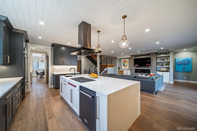kitchen featuring light countertops, hardwood / wood-style floors, island exhaust hood, and dishwasher