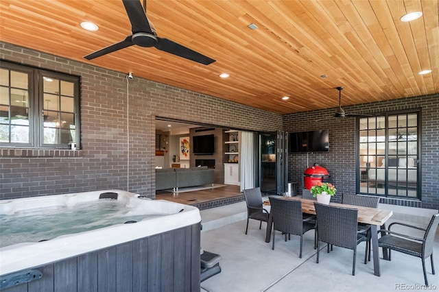 view of patio / terrace featuring a ceiling fan, a hot tub, and outdoor dining space