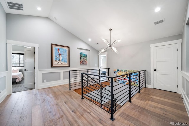 corridor featuring visible vents, an upstairs landing, wood-type flooring, a chandelier, and recessed lighting