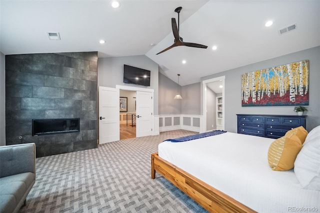bedroom featuring visible vents, carpet floors, lofted ceiling, and a tile fireplace