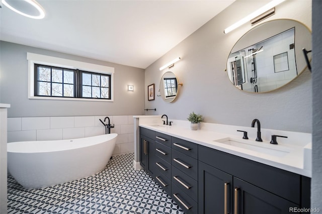 bathroom featuring a sink, tile walls, a soaking tub, and a wealth of natural light