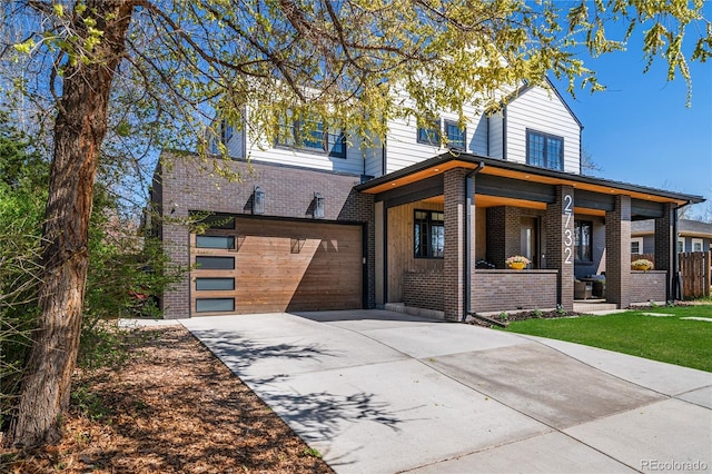 view of front of house featuring a garage, a porch, driveway, and brick siding