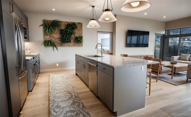 1643 Boulder St Unit 211, Denver, CO 80211 - kitchen featuring a sink, freestanding refrigerator, recessed lighting, a breakfast bar, and an island with sink