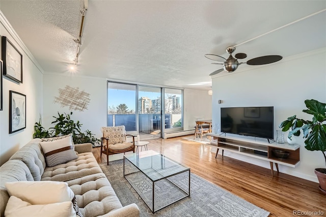 living area featuring a textured ceiling, a wall of windows, wood finished floors, and crown molding