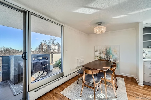 dining space with light wood finished floors, plenty of natural light, a wall of windows, and a textured ceiling