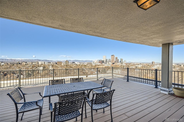 wooden deck with a view of city and outdoor dining space