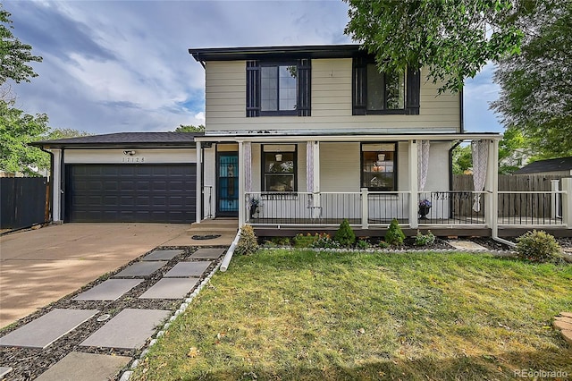 view of property featuring a front yard, covered porch, and a garage