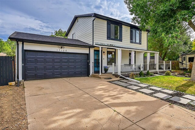 view of property featuring a garage, a front lawn, and covered porch