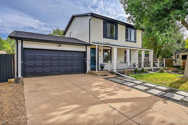 traditional-style home with concrete driveway, a porch, fence, and an attached garage