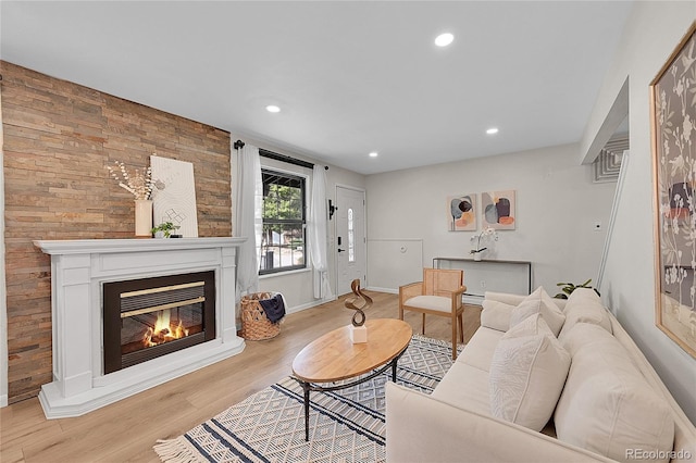 living room with a glass covered fireplace, baseboards, wood finished floors, and recessed lighting