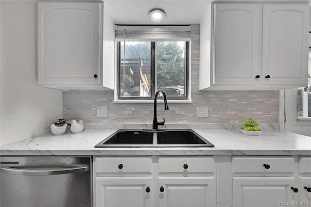 kitchen featuring a sink, light stone counters, tasteful backsplash, white cabinetry, and dishwasher