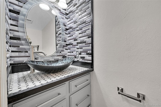 bathroom featuring vanity and a textured wall