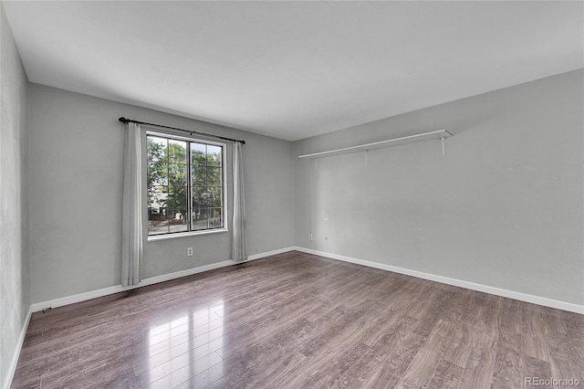 empty room featuring baseboards and wood finished floors