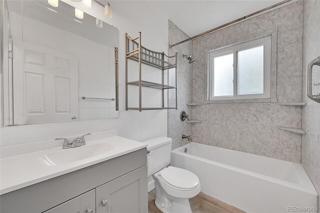 bathroom featuring toilet, vanity, bathing tub / shower combination, and wood finished floors