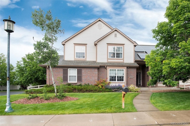 2959 W 110th Pl, Westminster, CO 80234 - traditional-style house with solar panels, brick siding, a front yard, and roof with shingles