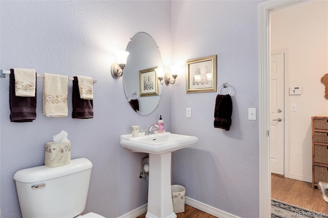 2959 W 110th Pl, Westminster, CO 80234 - half bath featuring wood finished floors, toilet, a sink, and baseboards