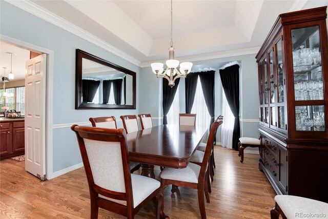 2959 W 110th Pl, Westminster, CO 80234 - dining area featuring a chandelier, light wood-type flooring, a raised ceiling, and ornamental molding