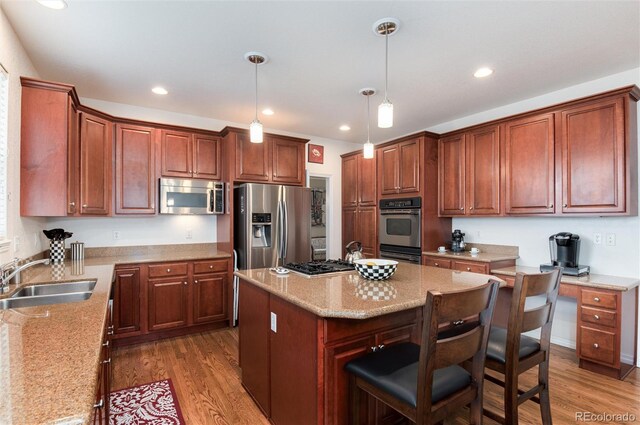 2959 W 110th Pl, Westminster, CO 80234 - kitchen with appliances with stainless steel finishes, a sink, wood finished floors, a center island, and recessed lighting
