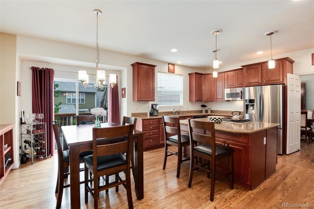 2959 W 110th Pl, Westminster, CO 80234 - kitchen with appliances with stainless steel finishes, a chandelier, a sink, a kitchen island, and pendant lighting