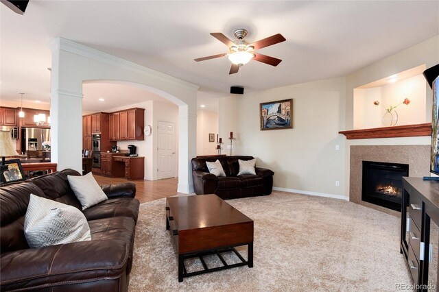 2959 W 110th Pl, Westminster, CO 80234 - living room with a ceiling fan, a glass covered fireplace, arched walkways, and baseboards