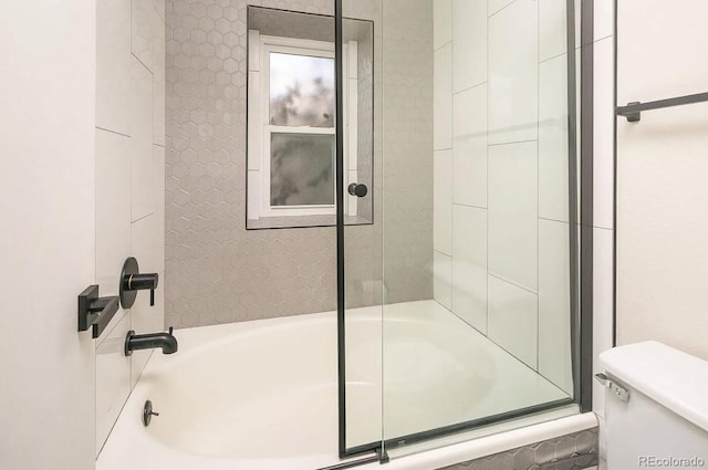 full bathroom featuring toilet and bath / shower combo with glass door