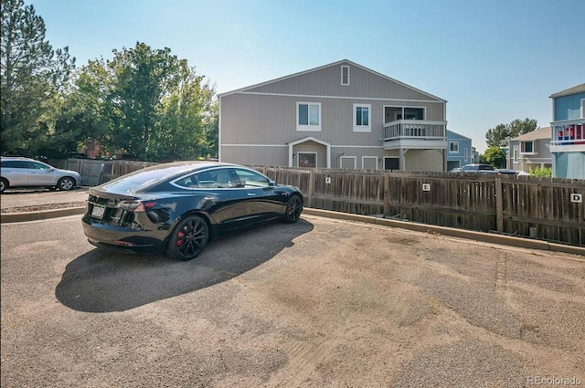 view of front of home featuring fence and uncovered parking
