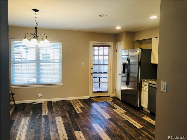 kitchen with dark wood-style flooring, white cabinets, black dishwasher, hanging light fixtures, and light stone countertops