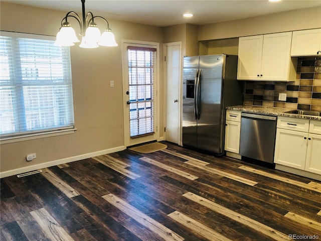 kitchen with visible vents, appliances with stainless steel finishes, light stone counters, white cabinetry, and pendant lighting