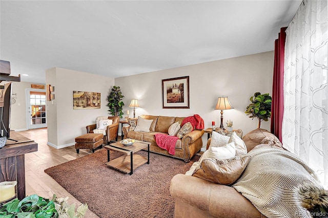 living room with baseboards and light wood-style floors