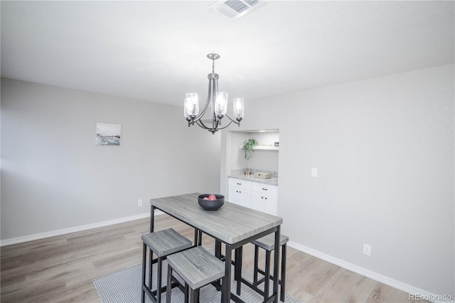 dining space with a chandelier and light wood-type flooring