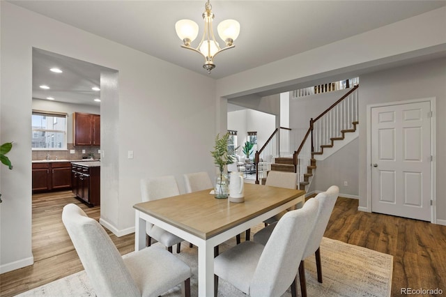 dining area with hardwood / wood-style flooring and a notable chandelier